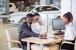 © alfa27 - Smiling african couple buying new car at new car showroom