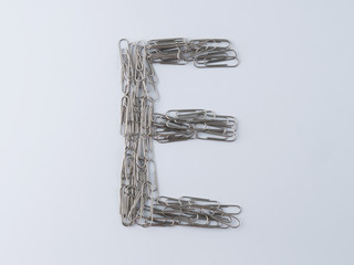 Letter E displayed with paperclips on white background