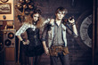 © SKfoto - Young beautiful couple in suits in steampunk style wearing glasses and with guns.
