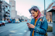 © bnenin - Hipster girl using phone at city street.