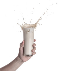 Sticker - Hand holding glass of milk with a splash isolated on a white background