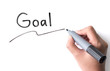 © showcake - Hand holding black permanent marker and writing word 'Goal'on white background