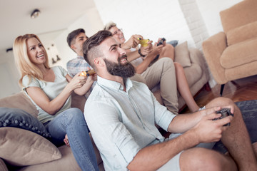 Wall Mural - Excited friends playing video games at home.