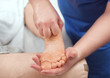 The doctor-podiatrist does an examination and massage of the patient's foot in the clinic.