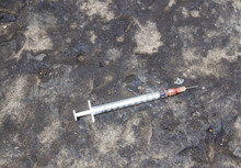 Substance Abuse, Addiction And Drug Use Concept - Close Up Of Used Syringes On Ground