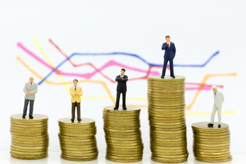 Miniature people: Group Businessman stand on stack of coins, display graphs, profit margins of  background. Image use for business concept.