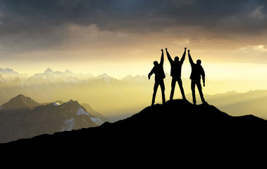 Wall Mural - silhouettes of team on mountain peak. sport and active life concept.