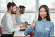 © DenisProduction.com - Asian girl praising colleagues. Japaneese girl shows her approval, thumb up.