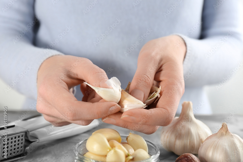Woman peeling garlic at table