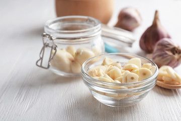 Canvas Print - Bowl with chopped garlic and cloves in jar on wooden table