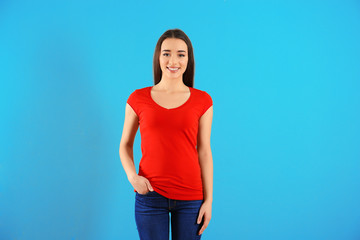 Wall Mural - Beautiful young woman in red t-shirt on color background. Mockup for design