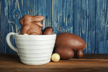 Wall Mural - Cup with chocolate Easter bunny and candies on table