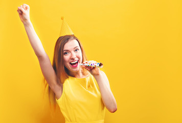 Wall Mural - Young woman with party theme on a yellow background