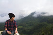 © Akira Kaelyn - Asian young man in Scottish shirt and black hat hiking at mountain peak above clouds and fog Hiker outdoor. Doi Luang Chiang Dao Chiangmai Province,In morning.