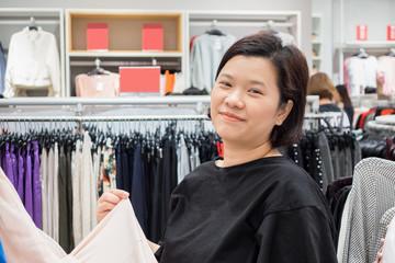 Beautiful asian woman shopping in fashion clothes store