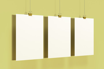 Wall Mural - Three blank white posters with binder clip mockup on yellow background