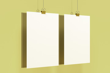 Two blank white posters with binder clip mockup on yellow background