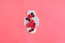White Sanitary Pad With Red And Pink Flowers On It, Woman Health Or Body Positive Concept. Pink Background.  Flatlay. Copyspace