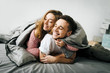 © stakhov - Cheerful couple under the coverlet in their bed. Artwork. Soft focus on the guy