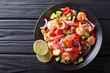 Delicious ceviche of shrimp with vegetables, spices and lime close up on a plate. horizontal top view