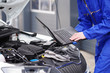 Mechaniker arbeitet mit einem Laptop an einem Auto, Motorsteuerung 