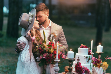 beautiful couple on wedding standing near cake and candles