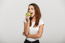 Portrait Of A Cheerful Young Woman Eating Green Apple