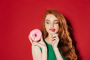 Wall Mural - Young pretty redhead girl with donut