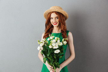 Sticker - Cheerful redhead young woman holding flowers.