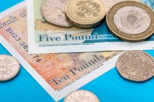 British Pound Money Bills And Coin On Blue