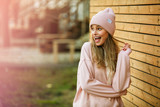 Fototapeta  - cool young woman in pink hoodie on wooden background