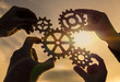© gerasimov174 - Four hands collect the gear from the gears of the details of the puzzles. against the background of sunlight. Concept business idea. Teamwork