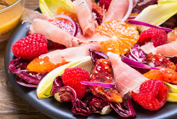 Salad with red radicchio and ham.Plate with appetizer.