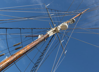 Wall Mural - Sailboat Mast  and ropes with cloudy blue sky in the background