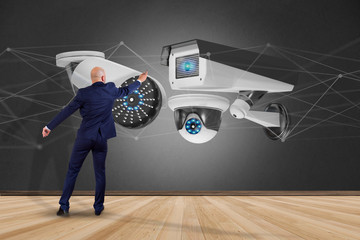 Poster - businessman holding a security camera system and network connection - 3d rendering