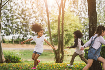 Wall Mural - Cute african american little girl playing outdoor - Black people kid and friend happy.