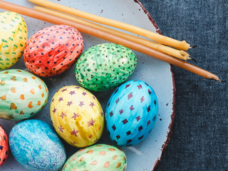 Easter eggs, painted with bright colors and candles. Happy easter!