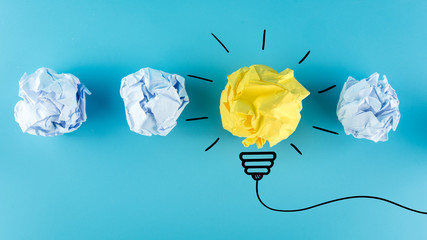 creative idea, inspiration, new idea and innovation concept with crumpled paper light bulb on blue b
