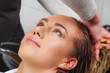 © Fotos 593 - Portrait of happy young woman with hairdresser washing head at hair salon, Beauty and people concept