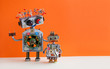 Creative design Robotic family. Big robot electrical wire hairstyle, plug arm. Small kid cyborg with lamp bulb toy. Copy space, orange wall background