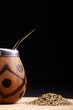 Traditional South American yerba mate tea in the calabash circle and Bombilla. Black background