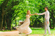 © Ivan - A pair of stylish clothes dancing in a park on the background of trees