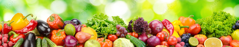 Panorama of fresh vegetables and fruits on blurred background of green leaves. - obrazy, fototapety, plakaty 