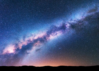 Wall Mural - milky way. fantastic night landscape with purple milky way, sky full of stars, yellow light and hill