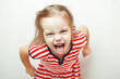 © Ilshat - Angry little girl shows her tongue in funny grimace