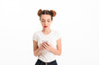 © Drobot Dean - Portrait of a confused casual girl holding mobile phone