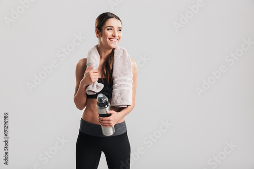 Εκτύπωση καμβά Healthy beautiful sportswoman wearing tracksuit with towel looking aside and hol