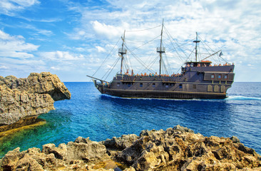 Wall Mural - The bridge of love or love bridge. Pirate ship sailing near famous Bridge of Love near Ayia Napa, Cyprus.