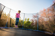 © Martinan - Girl afraid of jumping on trampoline bed
