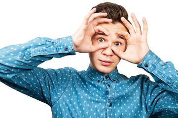 White young man open wide eyes with his fingers, isolated on white background.